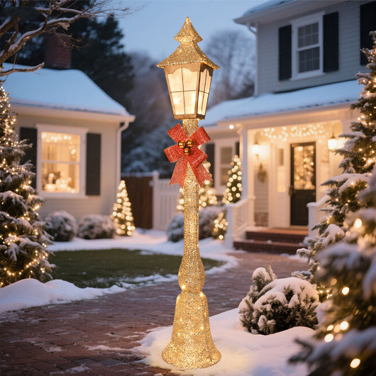 Lighted gold Christmas street lamp illuminating a snowy front yard walkway and winter holiday garden display