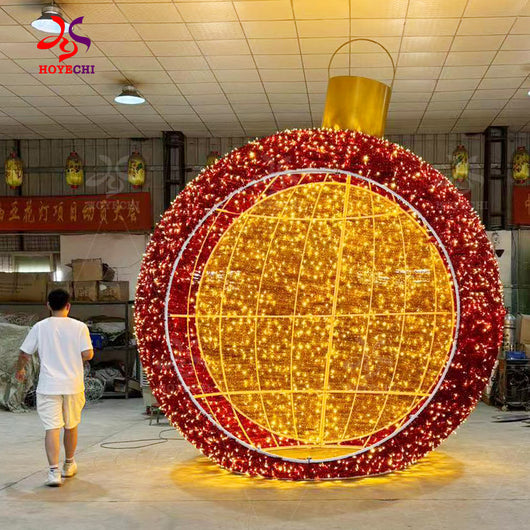 Man walking beside HOYECHI Christmas ball arch customized outdoor LED archway highlighting giant scale for city plazas and malls