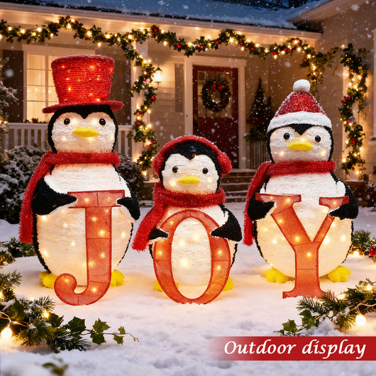 Outdoor display of HOYECHI lighted JOY penguin trio in snowy front porch Christmas yard scene