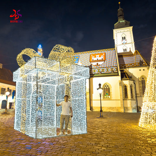 HOYECHI walk-through LED gift box arch outdoor Christmas decoration in city square with man standing inside