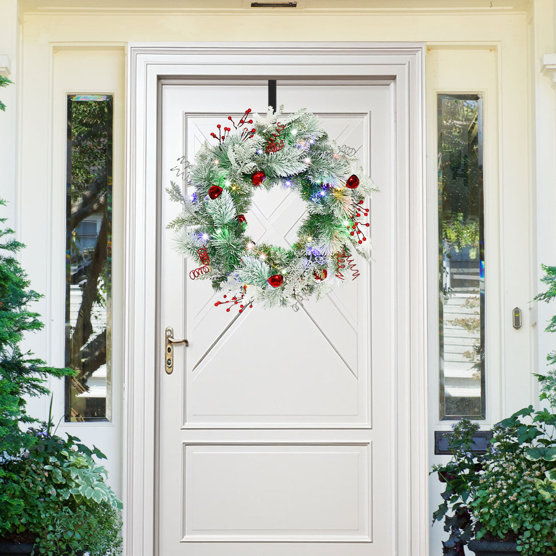 Image promotionnelle officielle d’une couronne HYC704 au feuillage d’aspect enneigé et aux grelots rouges sur une porte d’entrée blanche.